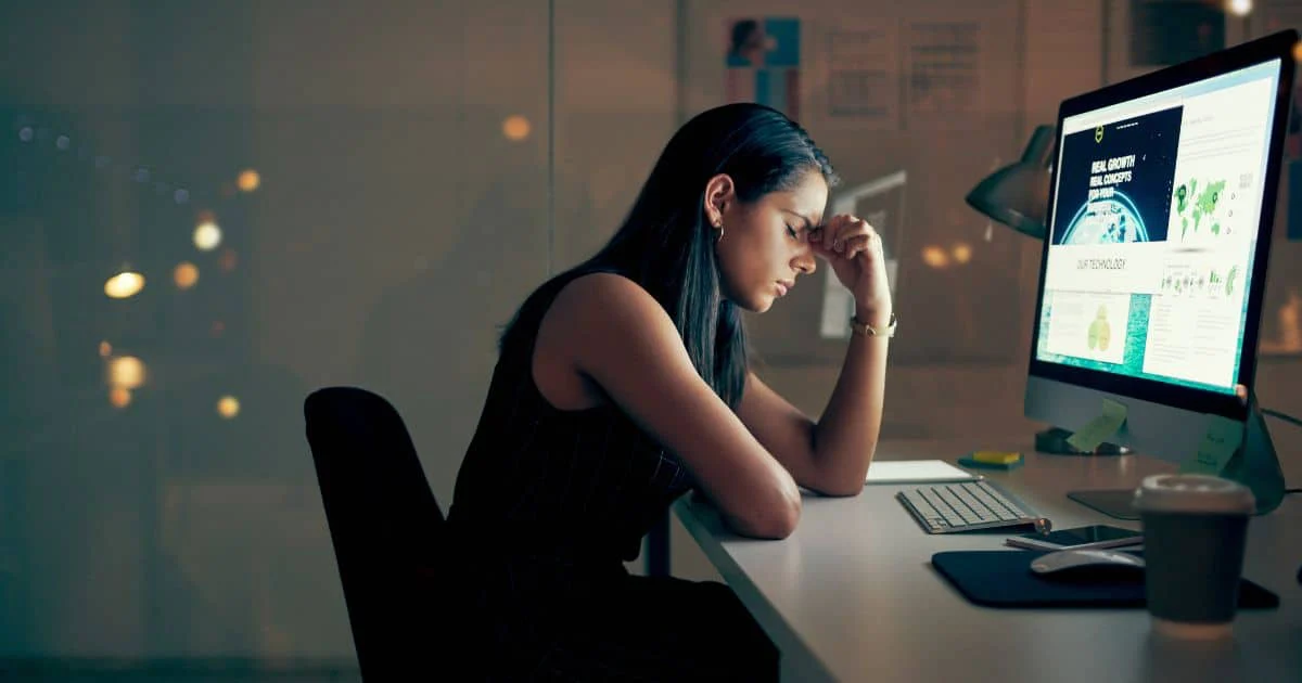 Woman sitting at desk suffering from stage 3 adrenal exhaustion